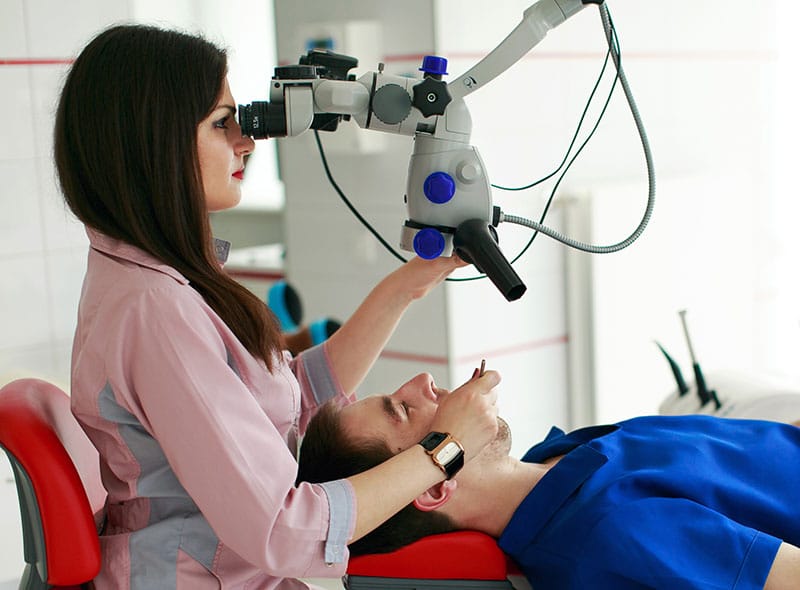 endodontist using a dental microscope