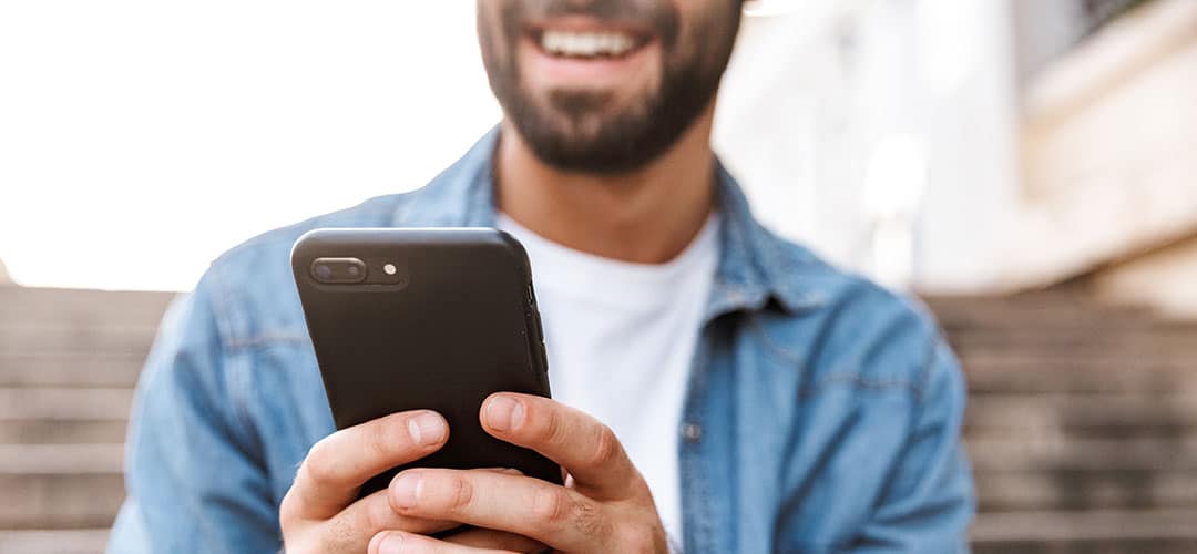 man holding phone and smiling